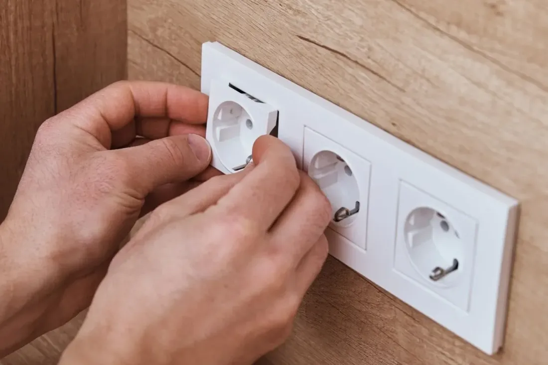 Montaż ramki potrójnego gniazda elektrycznego na wykończonej ścianie